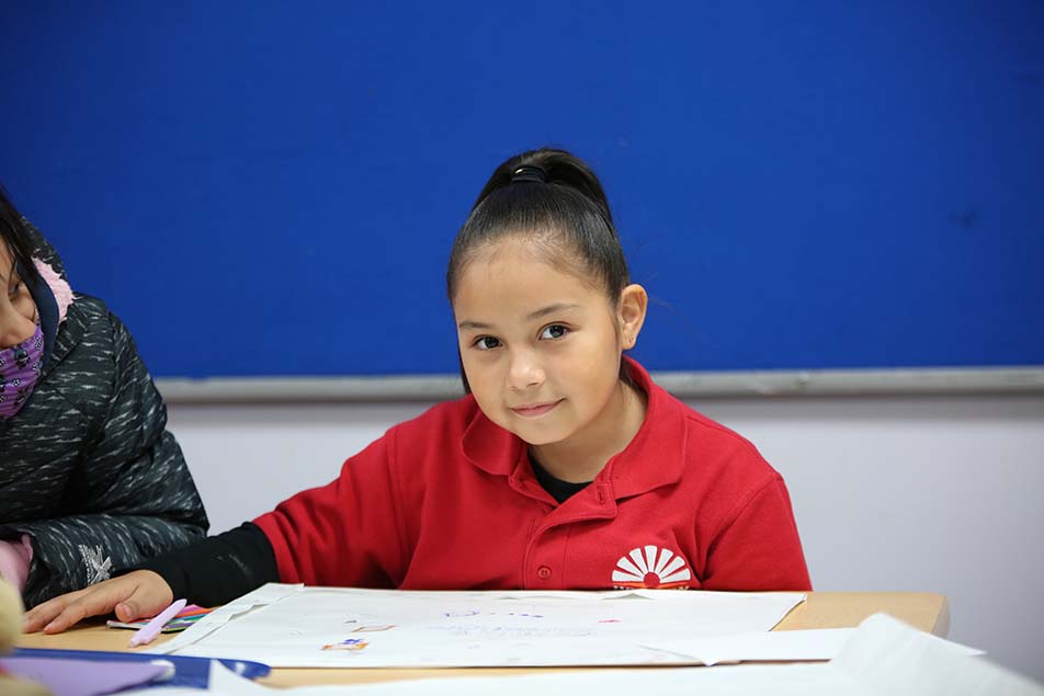 student in classroom smiling at camera