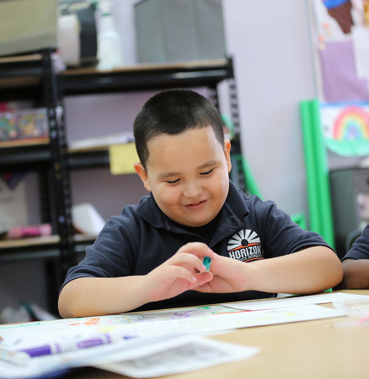 Student drawing in a classroom.